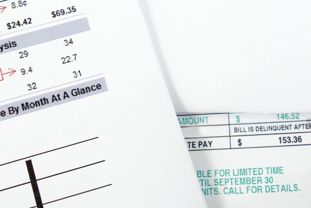 Close-up of household utility bills showing payment amounts and due dates.